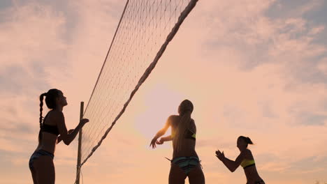 Sexy-Volleyballmädchen-Im-Bikini-Spielen-Im-Sommer-Am-Strand-Volleyball-Auf-Dem-Sand-Bei-Sonnenuntergang-In-Zeitlupe